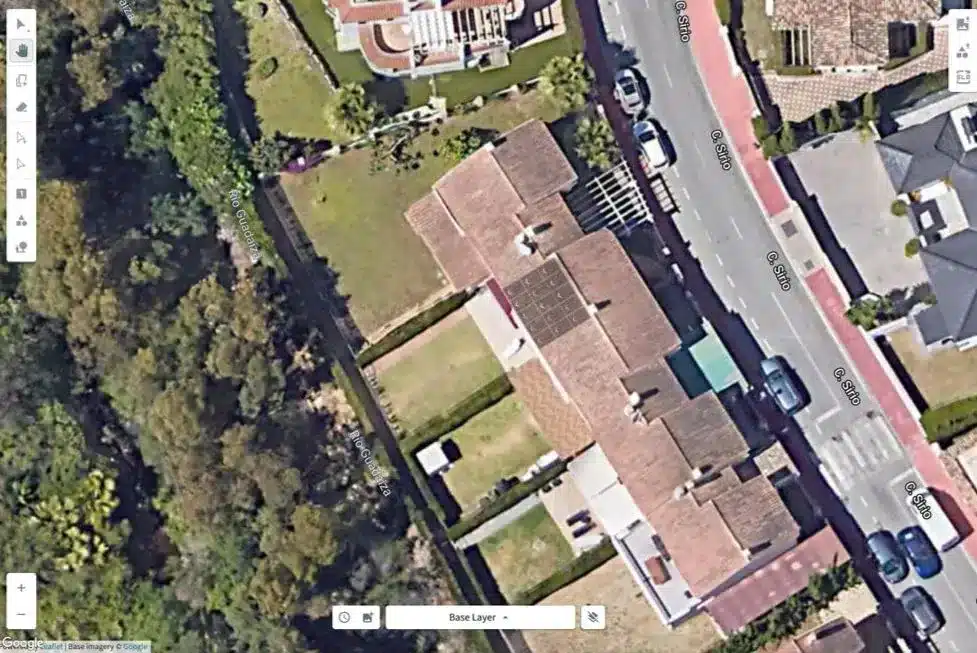 Vista aérea de una casa residencial con jardín, camino de entrada y vegetación circundante.