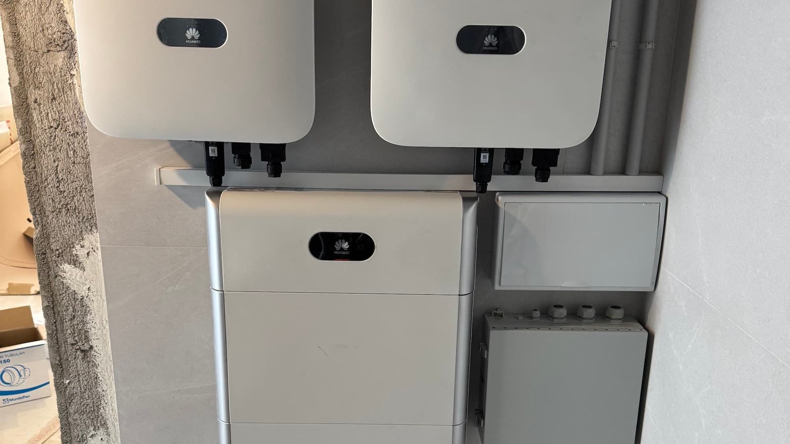 White electrical inverters mounted on a wall, used for solar power systems.