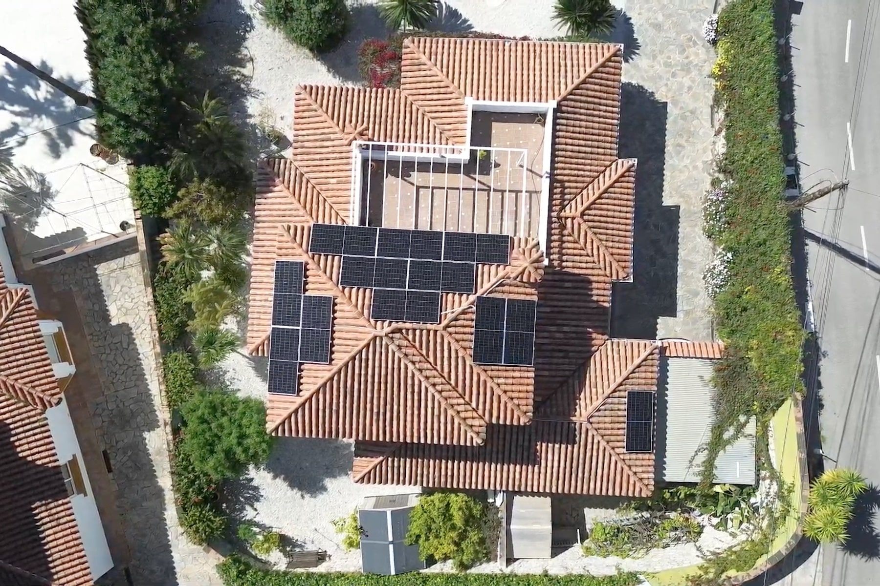 Aerial view of a large house with a complex terracotta tiled roof and surrounding greenery.